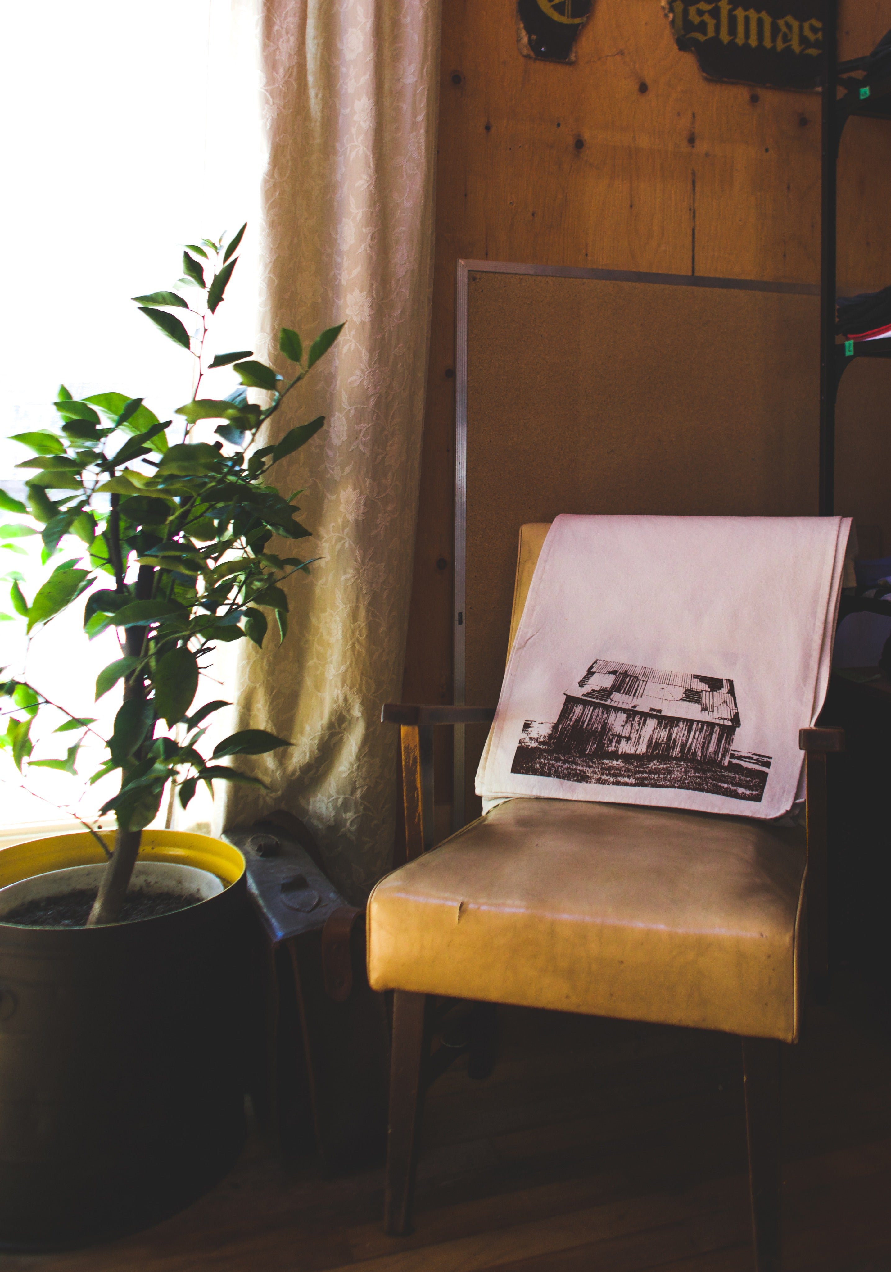 Tea towel of a hand printed barn on a chair